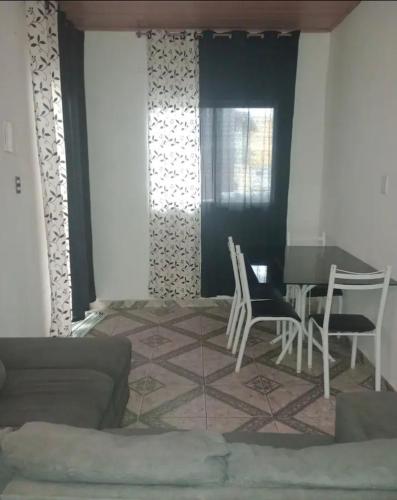 een woonkamer met een bank en een tafel en stoelen bij Casa em Diamantina in Diamantina