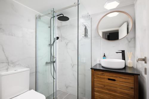 ein Bad mit einer Dusche, einem Waschbecken und einem Spiegel in der Unterkunft H Experience - Funky 1BD apartment in vibrant Nea Smirni in Athen