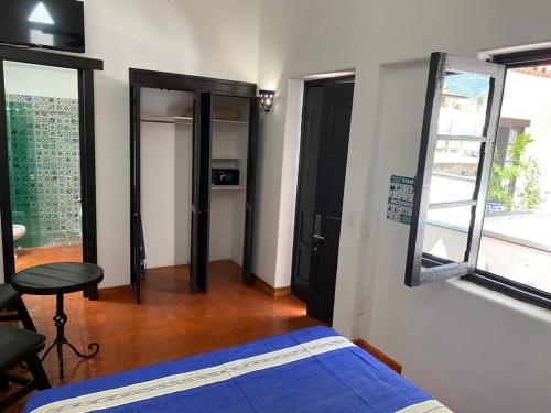a bedroom with a bed and a table and a window at Casa Yollotzin in Ajijic