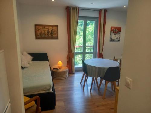 a room with a table and a bed and a window at LA DOVA MARMOTTE in Brides-les-Bains