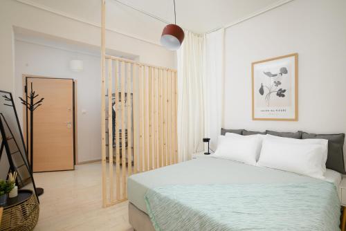 a bedroom with a bed with white pillows at H Experience - Funky 1BD apartment in vibrant Nea Smirni in Athens