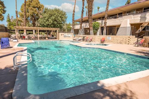 a swimming pool in a resort with palm trees at Palm Springs BLUE DESERT Condo! in Palm Springs