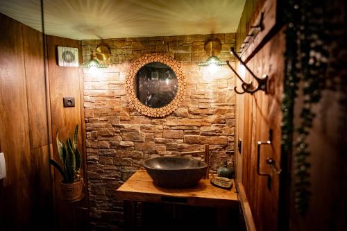 a bathroom with a sink and a stone wall at Le Mas de la Pouzolle in Le Garn