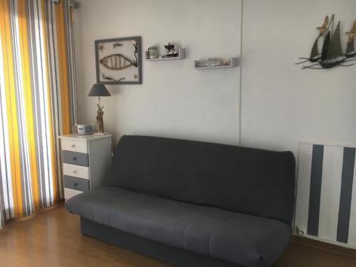a living room with a couch and a night stand at Appartement vue mer in Leucate