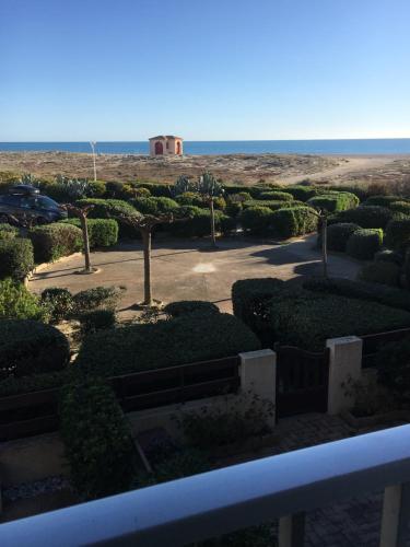 a view of a garden with a building in the background at Appartement vue mer in Leucate