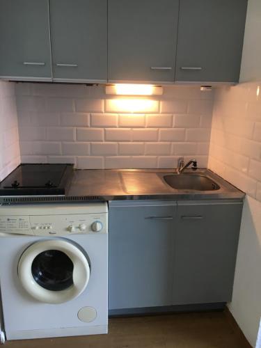 a kitchen with a washing machine and a sink at Appartement vue mer in Leucate