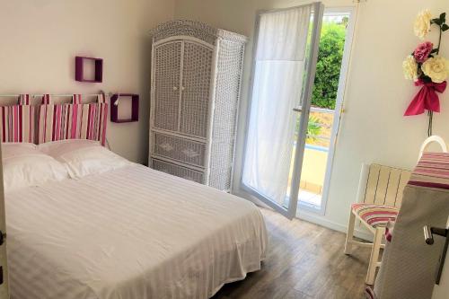 a bedroom with a white bed and a large window at Charming cocoon by the sea in Pornichet