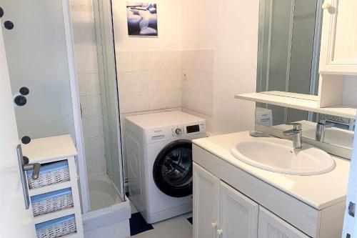 a bathroom with a washing machine and a sink at Charming cocoon by the sea in Pornichet