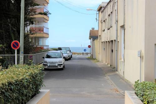 a street with cars parked on the side of the road at Charming cocoon by the sea in Pornichet