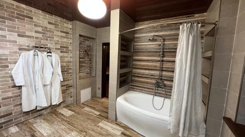 ein Bad mit einer Badewanne und einer Dusche mit einem Duschvorhang in der Unterkunft Lite Guest House in Bischkek