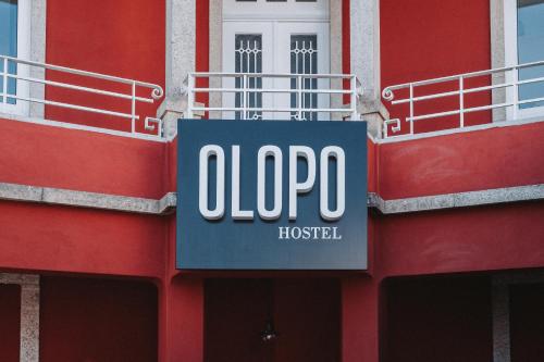 a sign on the side of a red building at OLOPO in Porto