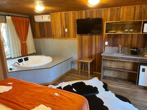 uma casa de banho com uma vaca deitada no chão em Hotel Cabanas Glamour em Gramado