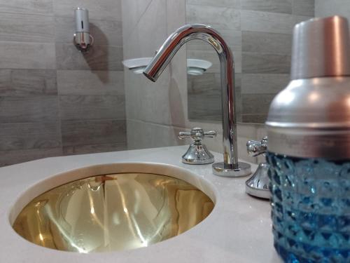 a sink with a bottle of water sitting next to it at Apartamentos Siete Cavas in Bahía Blanca