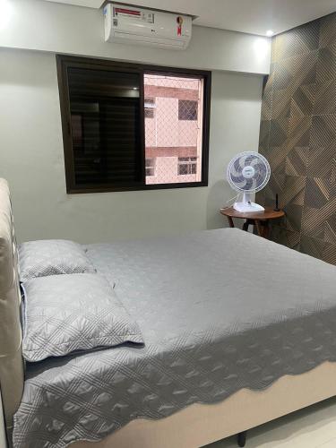 una camera con letto, finestra e ventilatore di Apartamento four seasons a Guarujá
