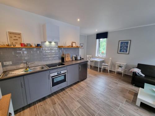 a kitchen and living room with a sink and a couch at Ferienwohnung Bad Doberan in Bad Doberan