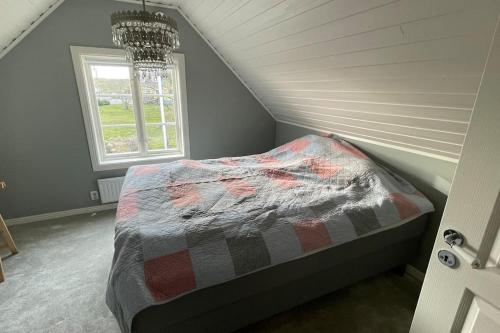 a bedroom with a bed in a attic with a window at Stort semesterhus med sol in Båstad
