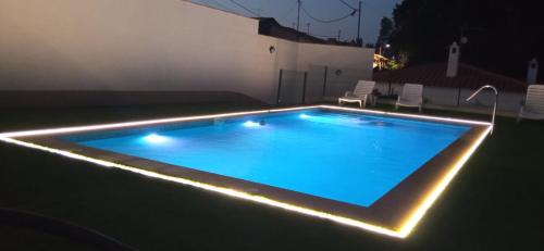 Alojamientos Rurales Villora في مورسية: حمام سباحة مع أضواء في الفناء الخلفي في الليل