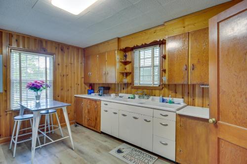 cocina con armarios de madera, fregadero y mesa en Historic Augusta Getaway with Screened Porch! en Augusta