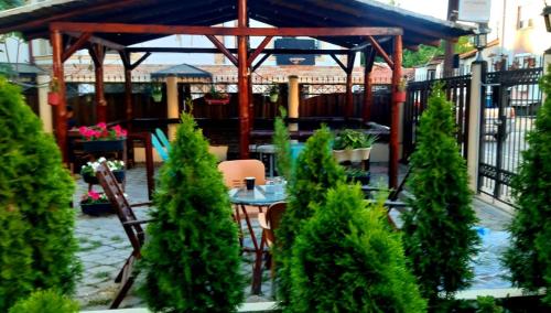 eine Terrasse mit einem Tisch, Stühlen und Bäumen in der Unterkunft City Hostel in Skopje