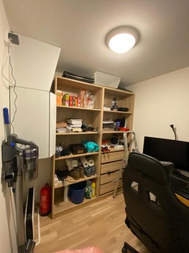 a room with a refrigerator and a book shelf at Ny og moderne 2-roms leilighet på Øvre Nyhavna in Trondheim