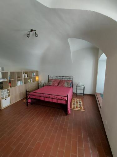 1 dormitorio con 1 cama rosa en una habitación en La casina in città - The little flat in town en Alessandria