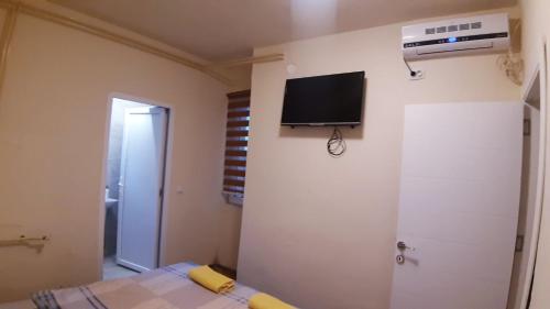 a bedroom with a bed and a tv on the wall at City Hostel in Skopje