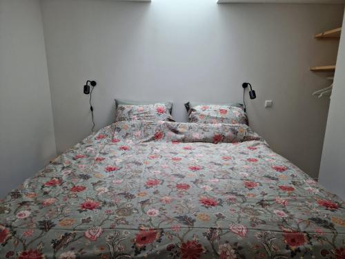 1 cama con colcha floral y almohadas en Fenix Edam, en Edam