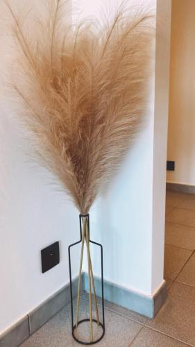a vase filled with feathers in a room at Malpertus in Bredene