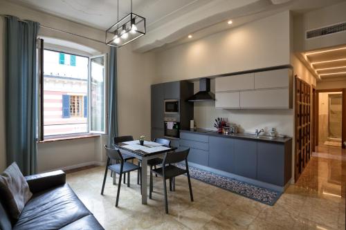 een keuken en eetkamer met een tafel en stoelen bij Le Due Piazze in Genua