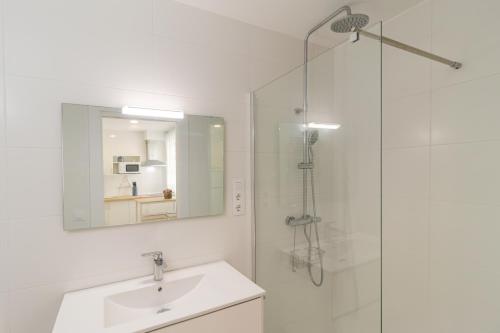 y baño blanco con lavabo y ducha. en Precioso apartamento con espectaculares vistas, en Santander