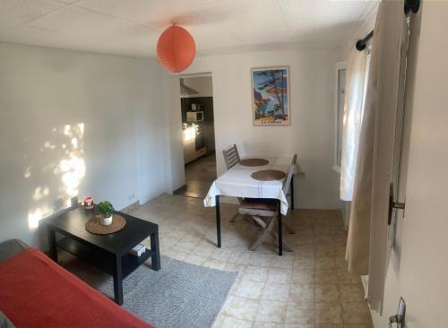 Una sala de estar con un sofá rojo y una mesa. en Rez de villa avec terrasse vue mer, en Bastia