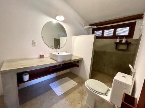 a bathroom with a sink and a mirror and a toilet at Controvento Boutique Hotel in Cumbuco