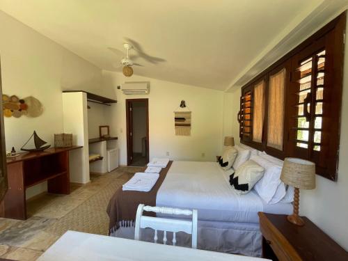 a bedroom with a large bed and a desk at Controvento Boutique Hotel in Cumbuco