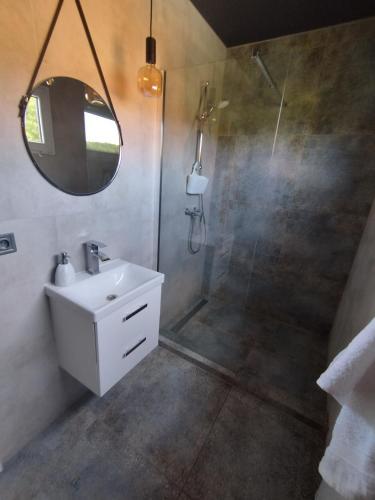 a bathroom with a shower and a sink and a mirror at Domki La Bella 2 in Aleksandria
