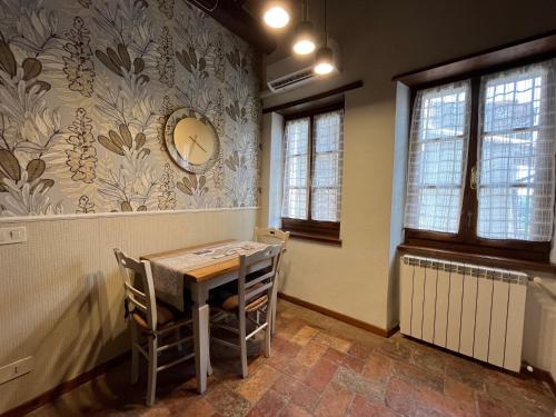 une salle à manger avec une table et une horloge murale dans l'établissement La soffitta nel Bastione, à Pitigliano