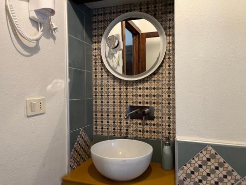 La salle de bains est pourvue d'un lavabo et d'un miroir. dans l'établissement La soffitta nel Bastione, à Pitigliano