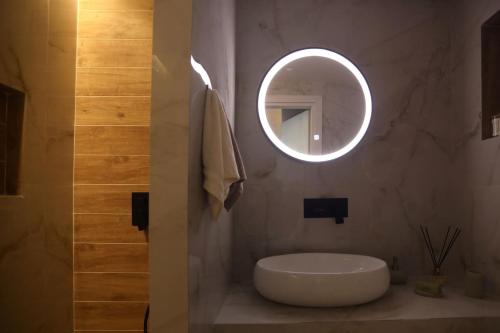 a bathroom with a white sink and a mirror at Calma Resort in Skála Foúrkas