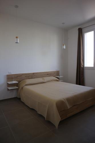 a bed in a white room with a window at L'Atelier di Vittoria in Carini