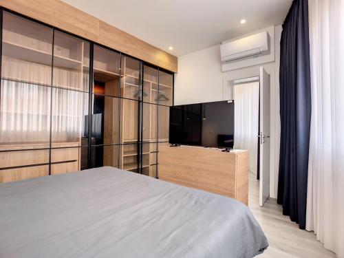a bedroom with a large bed and a flat screen tv at O Flamingo Apartments in Ovar