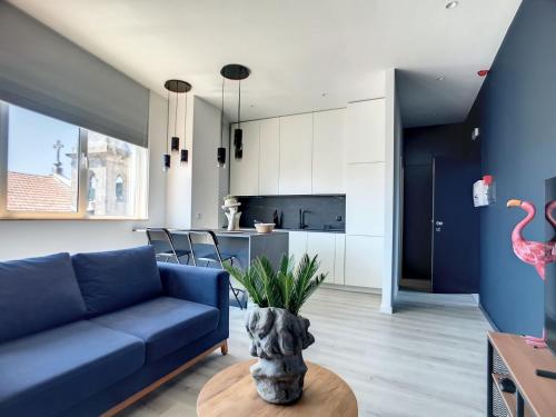 a living room with a blue couch and a table at O Flamingo Apartments in Ovar