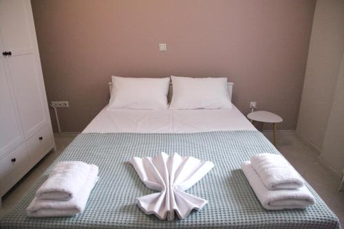 a bed with towels and a flower on it at Sea Front Retreat in Kavala