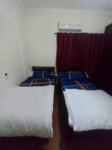 2 camas en una habitación pequeña con ventana en شقق سكنيه للايجار en El Cairo