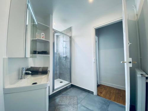 a white bathroom with a shower and a sink at Cozy Appart' 2 Centre ville proche gare Massy - Cozy Houses in Massy