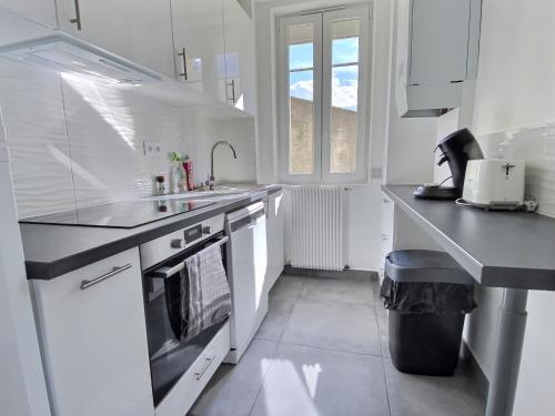 a white kitchen with a sink and a stove at Cozy Appart' 2 Centre ville proche gare Massy - Cozy Houses in Massy