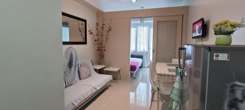 a living room with a couch and a refrigerator at Amigo's Place at Sea Residences in Manila