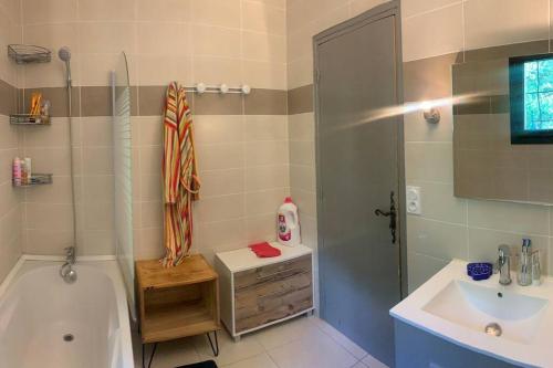 een badkamer met een bad, een wastafel en een douche bij Ferienhaus mit grandiosem Blick in Anduze