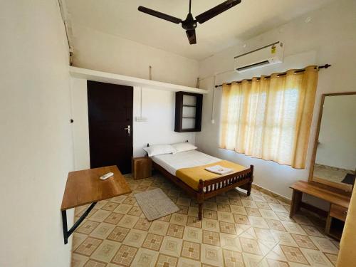 um pequeno quarto com uma cama e uma mesa em VayalMonk - Alleppey Island Isolated Villa resort em Alappuzha