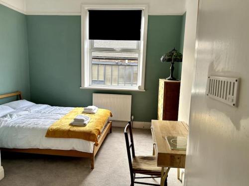 a bedroom with a bed and a table and a window at Suze's Stays in Harrogate