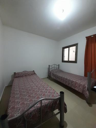 1 dormitorio con 2 camas y ventana en Departamento Del Bono Green en San Juan