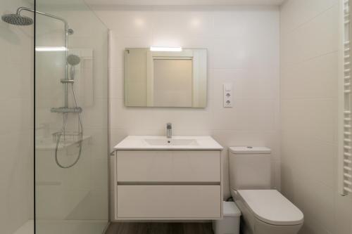 Baño blanco con lavabo y aseo en Amplio y bonito apartamento en La Maruca, en Santander